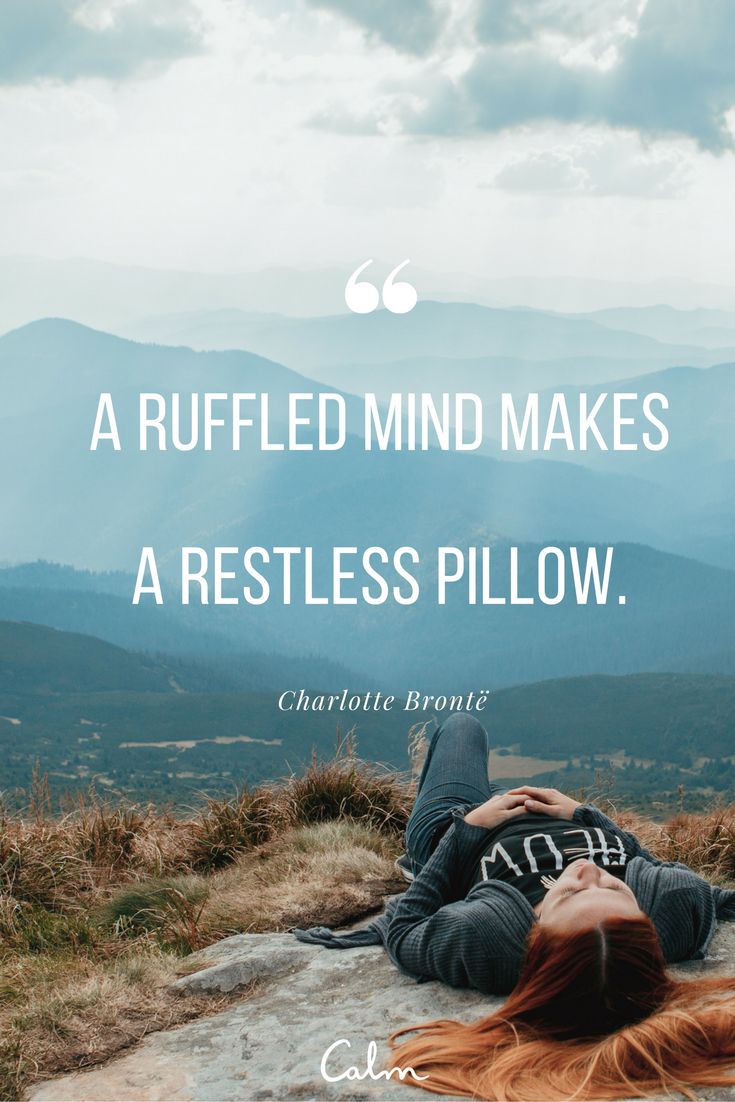 mindfulness quote on an image of a person lying on hill top with view of mountains in background